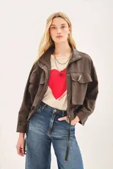 Campera marrón de lino con cierre frontal y bolsillos con solapa. Tiene mangas largas con presilla interna para arremangar.