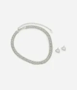 Conjunto de collar corto con strass y esferas, acompañado de caravanas con forma de corazones cutout. Producto confeccionado en metal reciclado con baño de níquel.