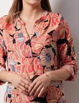 Blusa de gasa estampada con flores, marca Zac & Rachel. Tiene cuello a la base, escote en V y abertura con botones. Las mangas largas son de largo regulable.