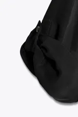 Camisa negra de Zara Woman Collection confeccionada en hilatura con mezcla de viscosa y lyocell. Tiene cuello solapa, manga por debajo del codo ajustable con trabilla y botón, bolsillo de plastrón en el pecho, bajo asimétrico redondeado y cierre frontal con botones.