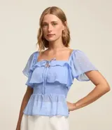 Blusa peplum de chiffon celeste con lunares blancos, escote cuadrado con lazo, mangas cortas godê, lastex en la espalda y pedrería de strass aplicada.