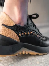 Zapatillas deportivas urbanas de cuero vacuno color blanco con detalles en cuero color beige y trenzado artesanal.