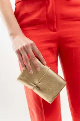 Billetera tipo sobre de cuero negro con cierre de elástico, separaciones internas y bolsillo con cierre para monedas.