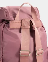 Mochila de tela color lila, con solapa con broche y tira de ajuste, doble bolsillo frontal con broche y pouch con charm lateral en forma de cartera.