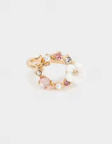 Anillo dorado con forma de corona de flores y strass de colores.