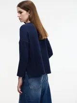 Sweater azul marino de manga larga con cuello redondo y bolsillo en el frente.