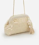 Clutch pequeño color crema con lentejuelas, correa de cadena dorada, cierre con cuentas y borla colgante con caracolas artificiales.