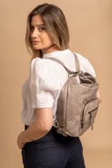 Cartera mochila color tostado, símil cuero, con compartimiento principal amplio y bolsillos frontales con cierre. Tiene correas ajustables para usar como mochila y asa superior para llevar al hombro.