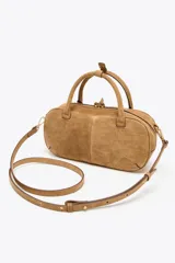 Bolso mini bowling color camel de serraje, con doble asa de mano y correa bandolera extraíble. Tiene un bolsillo interior con cremallera y cierre principal con cremallera y tirador.