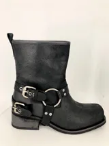 Bota corta negra de cuero con hebillas y arnés metálico.
