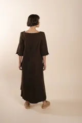 Vestido largo debajo de la rodilla, acampanado, color marrón, con cuello bote, bolsillos en el corte y mangas 3/4.