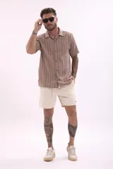 Camisa de manga corta con estampado a rayas verticales en tonos beige, marrón y celeste.