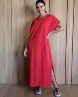 Vestido largo rojo de corte recto, con mangas cortas y aberturas laterales.