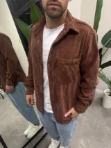 Sobrecamisa marrón de pana con cuello clásico, cierre abotonado y bolsillo de parche en el pecho.