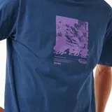 Remera azul de manga corta con estampa rectangular en el pecho con imagen de surf y logo de la marca Rip Curl.