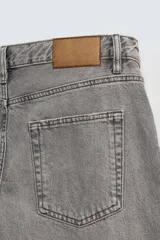 Pantalón de jean azul de corte recto, con cinco bolsillos, efecto lavado y cierre frontal con botonadura.