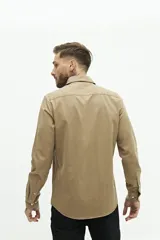 Camisa de manga larga color beige, de corte clásico y fit regular.