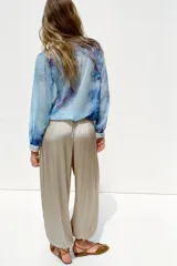 Pantalón bombacho color beige de tiro alto, con elástico en la cintura y en los tobillos.