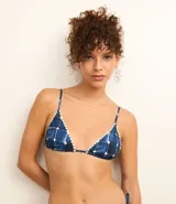 Top de bikini triangular con estampado de azulejos azules y blancos, breteles finos ajustables y detalle de volados en los bordes.