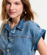 Mono corto de jean azul, con cuello camisero, cierre abotonado frontal, mangas cortas con dobladillo, trabillas en la cintura y bolsillos delanteros y traseros.