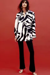 Blazer con estampado animal en blanco y negro, cuello solapa de muescas y manga larga acabada en abertura y botones. Bolsillos con solapa en delantero y de vivo en pecho. Cierre frontal cruzado con botones.