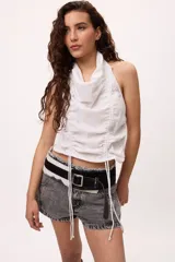 Top blanco sin mangas con cuello halter y frunces ajustables en el frente. Confeccionado en algodón y lino.