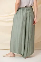 Pantalón palazzo blanco de viscosa, con cintura elastizada, cinto trenzado y bolsillos laterales.