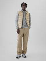 Chaleco puffer color verde militar con cierre frontal, cuello alto y logo de Gap bordado en el pecho.