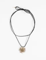 Collar con cordón negro ajustable y dije dorado con forma de sol texturizado.