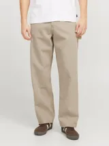 Pantalón jean color arena, de corte amplio, tiro alto y diseño de carpintero con múltiples bolsillos.