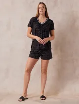 Conjunto de pijama marca René Rofé, compuesto por short y remera de tejido soft estampado. La remera tiene escote redondo con aplique de puntilla y detalle plisado. El short tiene cintura elastizada.