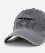 Gorra gris de sarga de algodón con efecto desteñido, visera curva y ajuste trasero con hebilla. Presenta bordado frontal con la frase "rule breaker" simulando rayos.