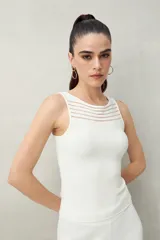 Musculosa blanca de tejido acanalado, con escote redondo y detalle de transparencias horizontales en la parte superior.