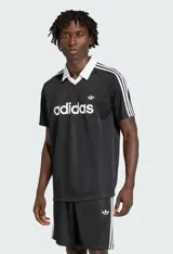 Jersey deportivo Adidas Originals de corte regular, color negro con textura de rayas verticales sutiles. Presenta cuello tipo polo en V con ribete blanco, tres rayas blancas en las mangas y el logo Trefoil bordado en blanco en el pecho.