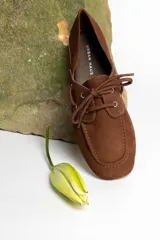 Mocasines color marrón claro con cordones y detalle de costuras en la puntera.