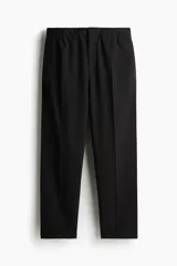 Pantalón negro de corte relajado, con cintura elástica ajustable con cordón, cierre con botón y corchete, bolsillos laterales y traseros.