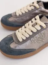 Championes urbanos de cuero color plateado con puntera de gamuza azul y cordones blancos.