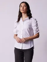 Camisa blanca de algodón, marca Zac & Rachel. Cuello a la base con solapa y escote en V. Abertura central con botones. Mangas 3/4 con frunce. Laterales en tejido modal.