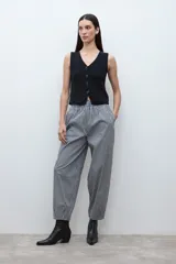 Pantalón de tiro alto, corte ancho y holgado, con elástico en la cintura. Confeccionado en tela estampada a cuadros vichy en blanco y negro.