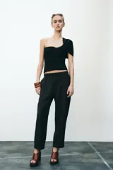 Pantalón tobillero negro con cintura elástica ajustable con cordones, bolsillos delanteros y falsos bolsillos con solapa en la espalda.