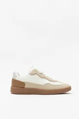 Zapatillas urbanas color beige y blanco, de gamuza y símil cuero, con suela de goma de 2,5 cm de altura.