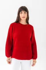 Sweater verde de punto con cuello redondo y mangas largas.