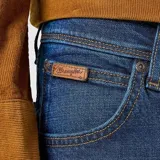 Jean Wrangler modelo Texas Slim de corte ajustado, color azul oscuro. Confeccionado en denim elástico. Presenta el clásico estilo de cinco bolsillos, siete trabillas para el cinturón, la costura en forma de «W» y el distintivo parche de piel marrón Wrangler en el bolsillo trasero.