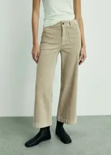 Pantalón culotte de pana color beige, con tiro alto, diseño crop, cierre de cremallera y botón, trabillas, dos bolsillos de parche delanteros y dos traseros.