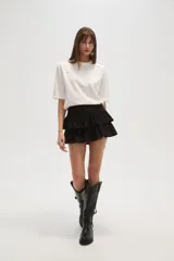 Remera blanca de algodón con tachas plateadas y cuello redondo.