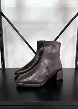 Botas cortas de cuero vegano color marrón chocolate, con punta cuadrada y taco geométrico.