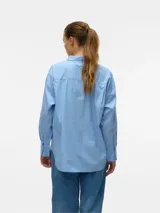 Camisa celeste a rayas blancas, holgada con cuello clásico, mangas largas y cierre de botones.
