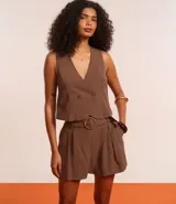 Short verde esmeralda de cintura alta, corte sastrero, con trabillas, pliegues y bolsillos. Incluye cinturón de tela con hebilla redonda.