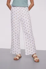 Pantalón holgado y largo de algodón, con estampado de flores en tonos suaves sobre fondo blanco.