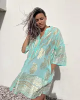 Camisola verde agua con estampado dorado de estilo hindú, mangas 3/4 y cuello en V.